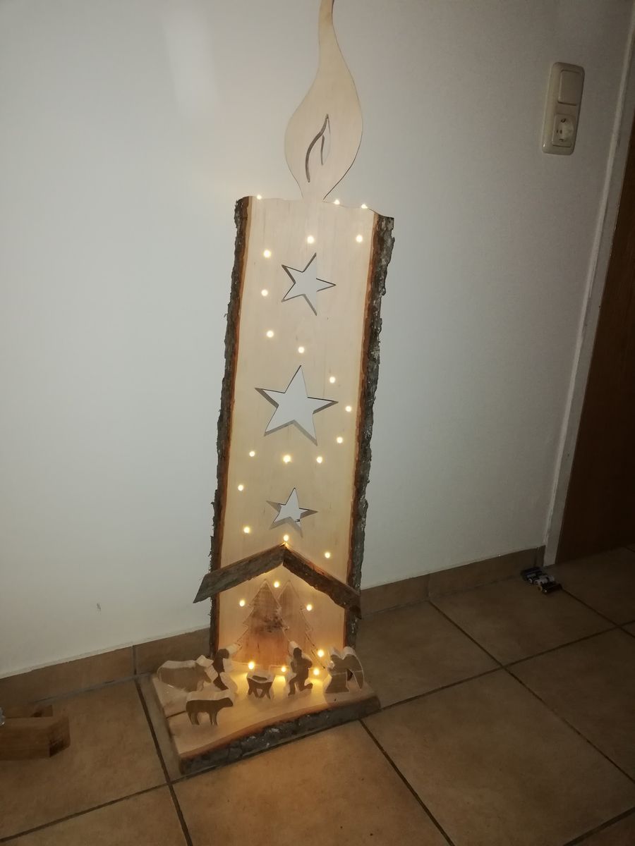 Holzkerze mit ausgesägten Sternen und Lichterkette